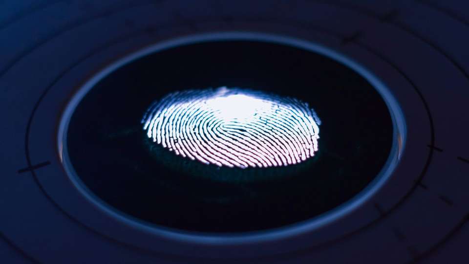 A glowing fingerprint on a round biometric scanner