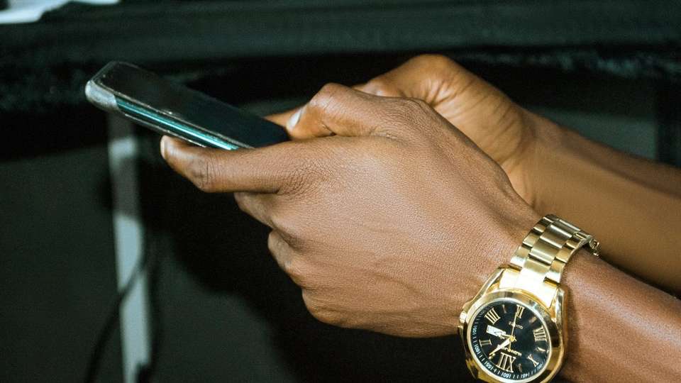 Close-up of hands typing on a smartphone