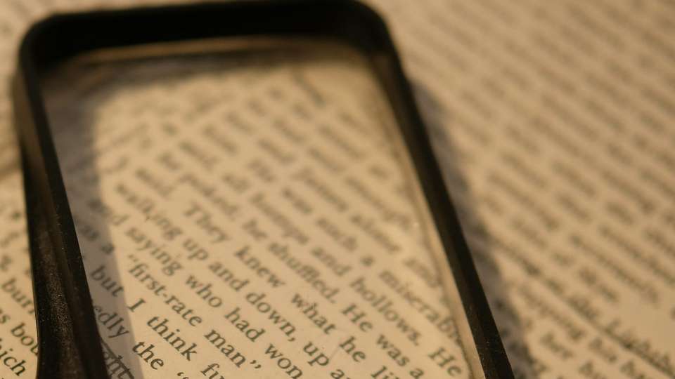 A magnifying glass over a page of printed text