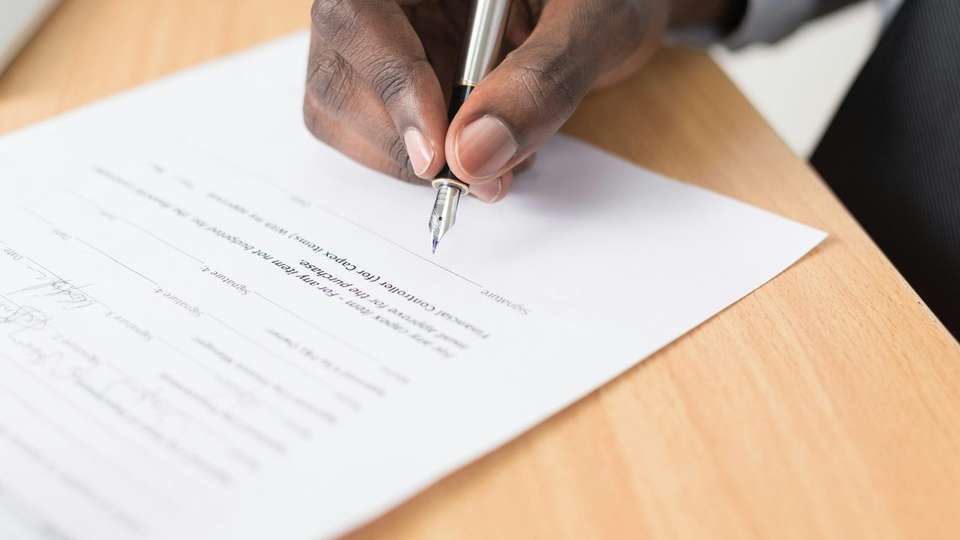A hand writing on a printed letter with a fountain pen