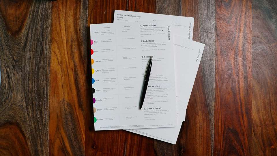 Printed pages and a pen on a wooden table