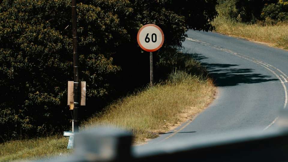 A 60 km/h speed limit sign beside a winding road in Margate, KwaZulu-Natal