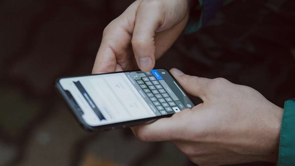 Hands holding a smartphone and typing
